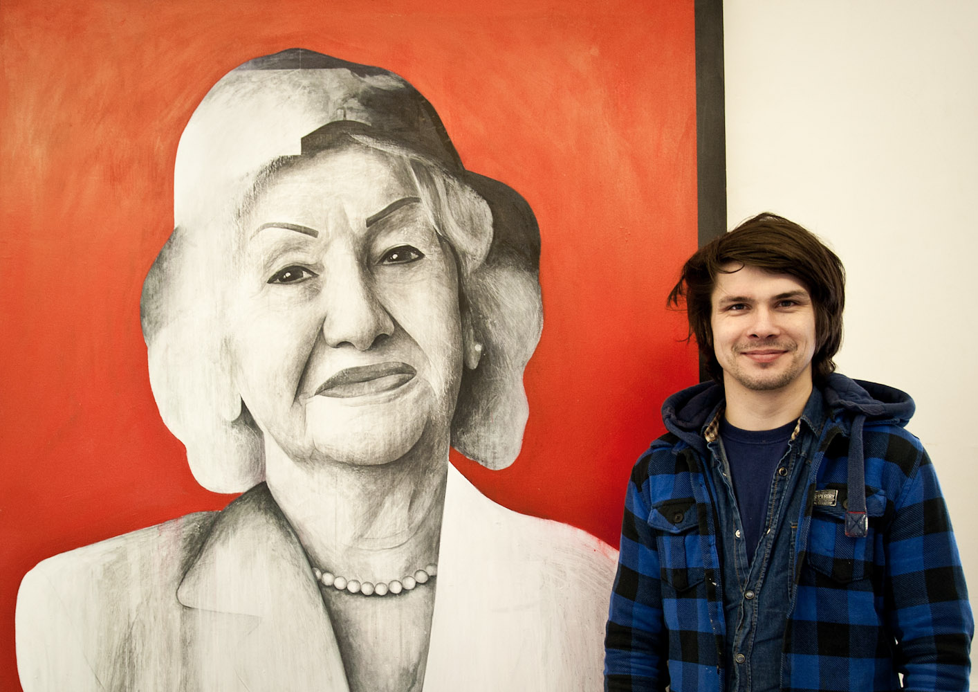 Ben Slow standing next to his painting of Fatemah Feshangchi Ben Slow standing next to his painting of Fatemah Feshangchi